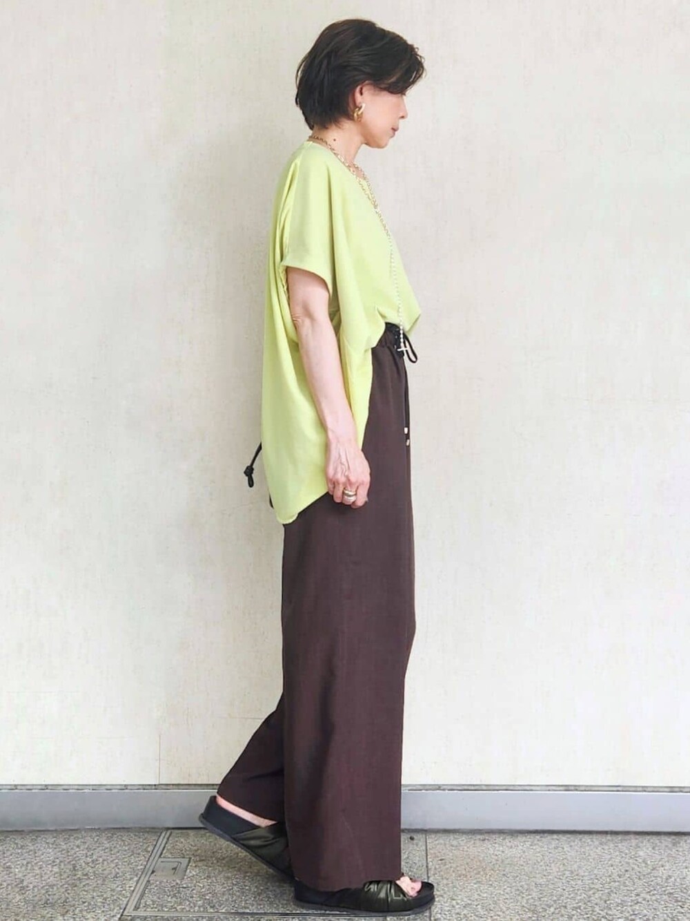 グリーン系のTシャツ/カットソー、グリーン系のサンダル、ブラウン系のその他パンツを着用したレディースの夏コーディネートの4枚目の写真