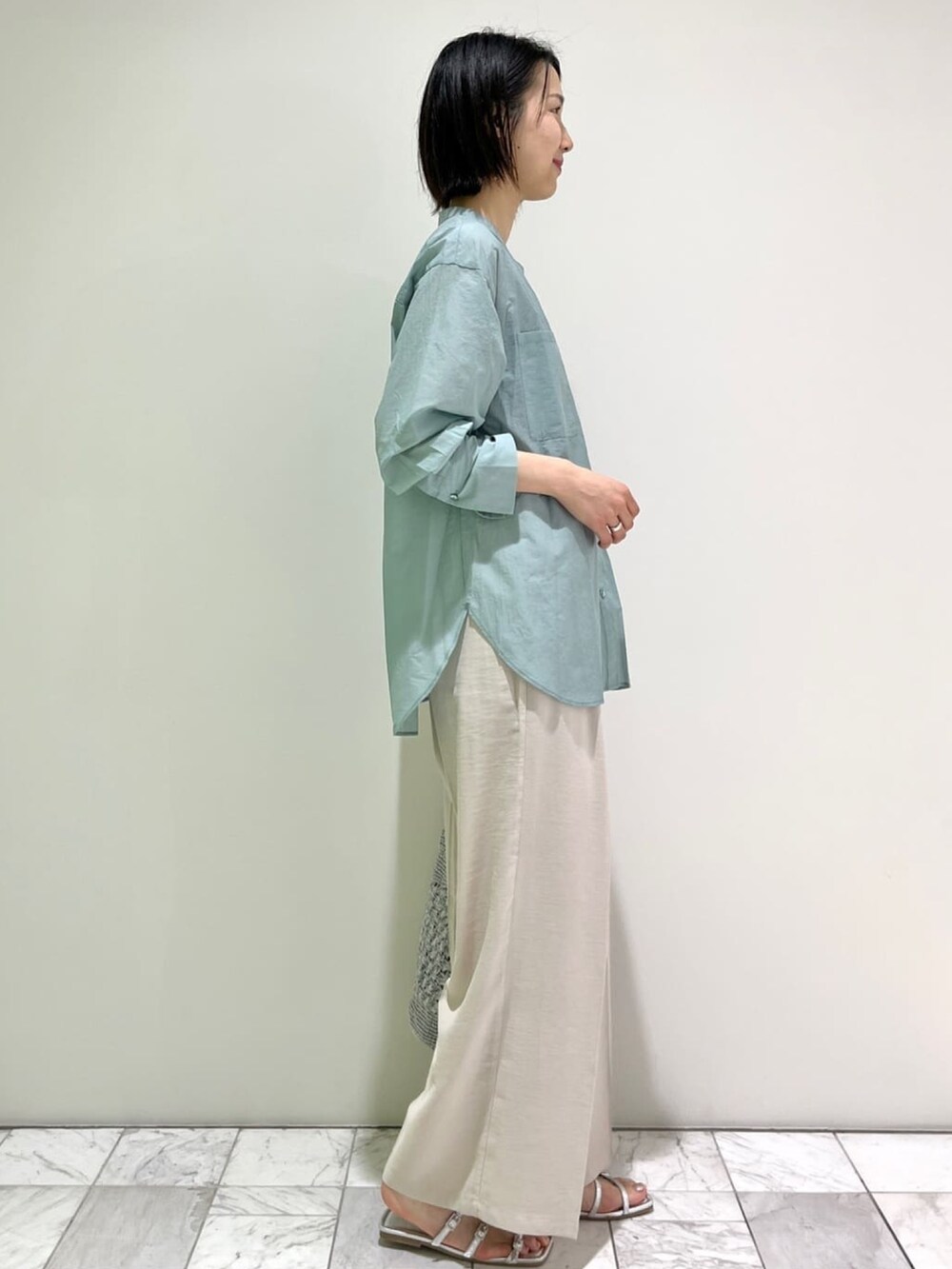 グリーン系のシャツ/ブラウス、ベージュ系のその他パンツ、シルバー系のトートバッグを着用したレディースの春コーディネートの3枚目の写真