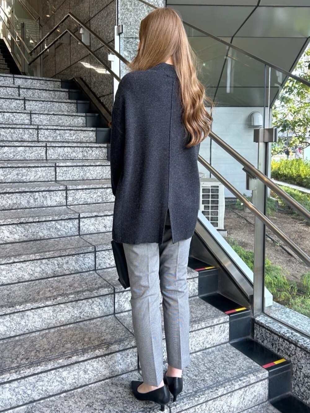 グレー系のニット/セーター、ブラック系のその他パンツ、ブラック系のトートバッグを着用したレディースの冬コーディネートの4枚目の写真