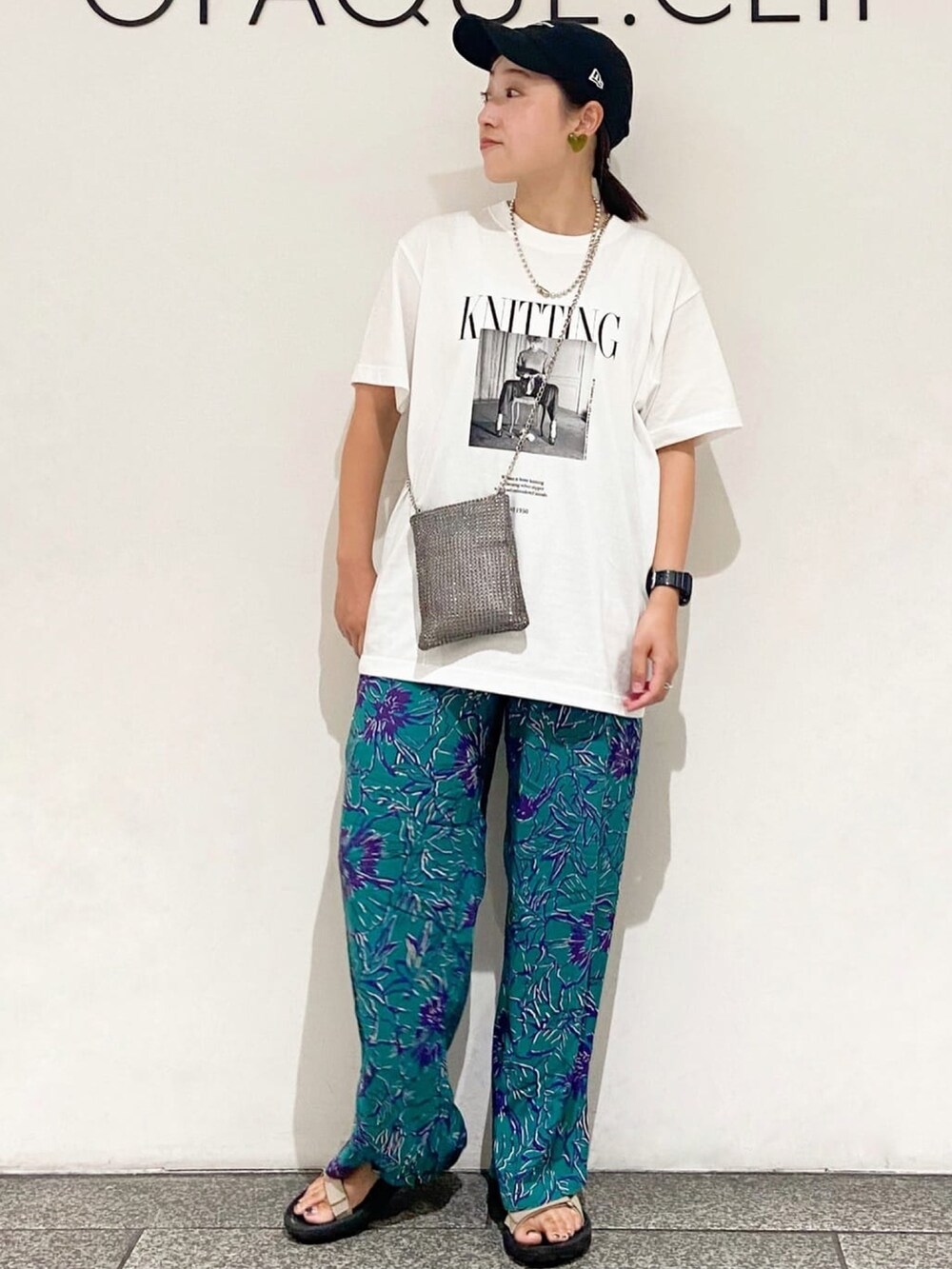 グレー系のショルダーバッグ、グリーン系のその他パンツ、ホワイト系のTシャツ/カットソーを着用したレディースの夏コーディネートの3枚目の写真