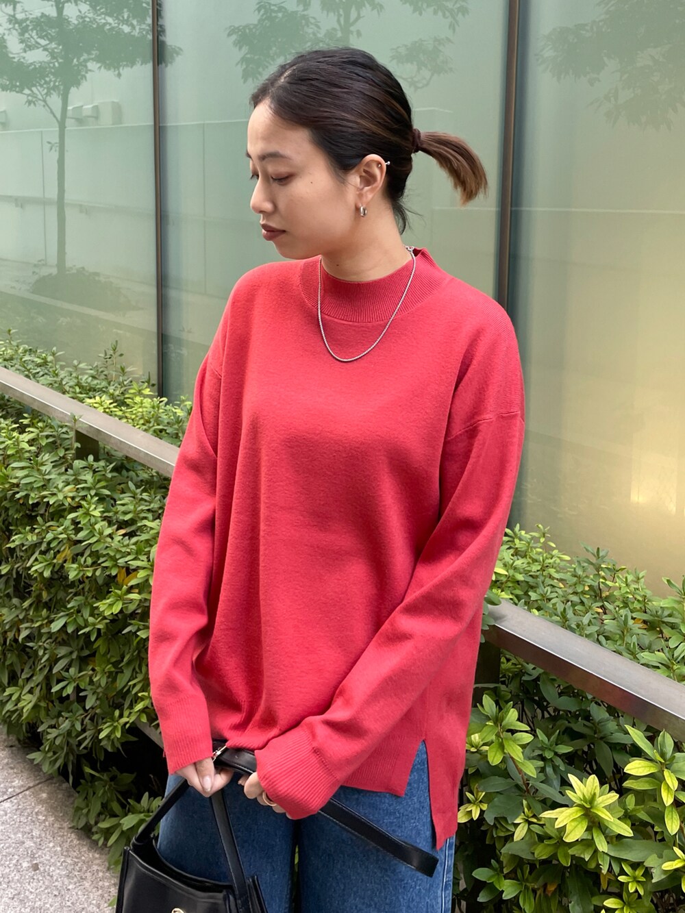 レッド系のニット/セーター、ブルー系のその他パンツ、ブラック系のブーツを着用したレディースの冬コーディネートの4枚目の写真