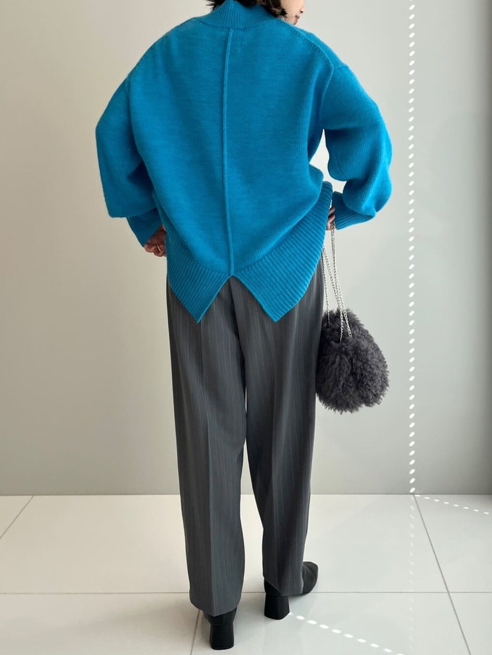 ブルー系のニット/セーター、グレー系のその他パンツ、グレー系のショルダーバッグを着用したレディースの秋コーディネートの3枚目の写真