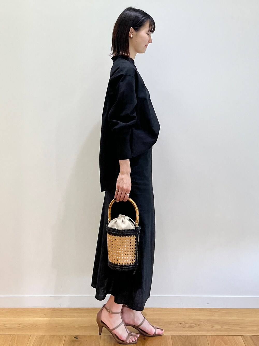 ブラウン系のサンダル、ブラック系のシャツ/ブラウス、ブラック系のトートバッグを着用したレディースの春コーディネートの3枚目の写真