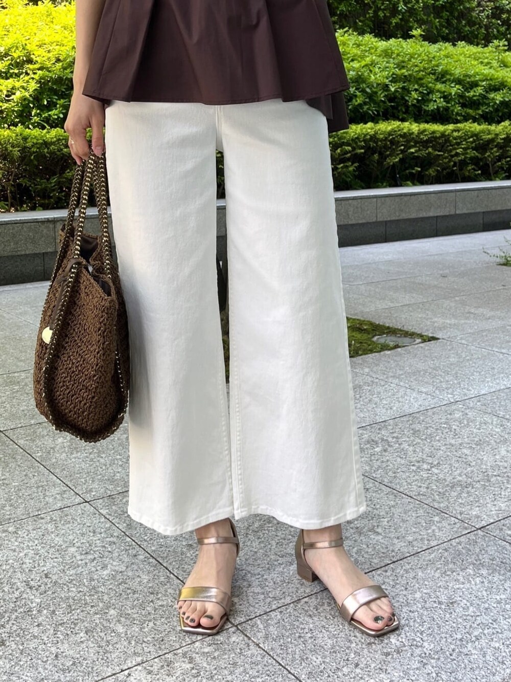 ブラウン系のTシャツ/カットソー、ホワイト系のデニムパンツ、ゴールド系のサンダルを着用したレディースの夏コーディネートの5枚目の写真