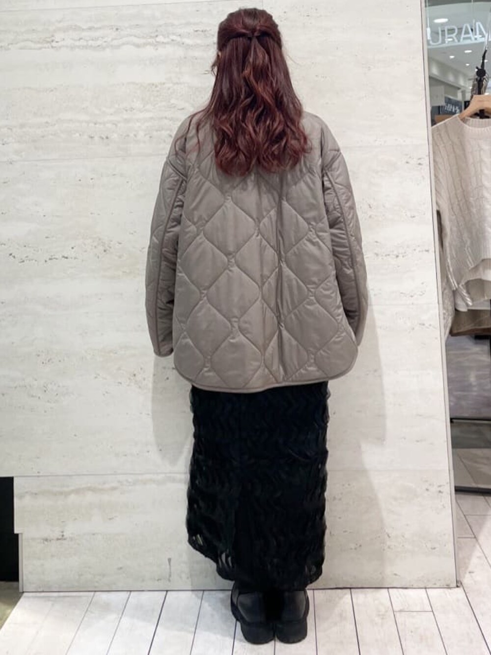 ブラウン系のノーカラーコート、イエロー系のニット/セーター、ブラック系のスカートを着用したレディースの冬コーディネートの4枚目の写真