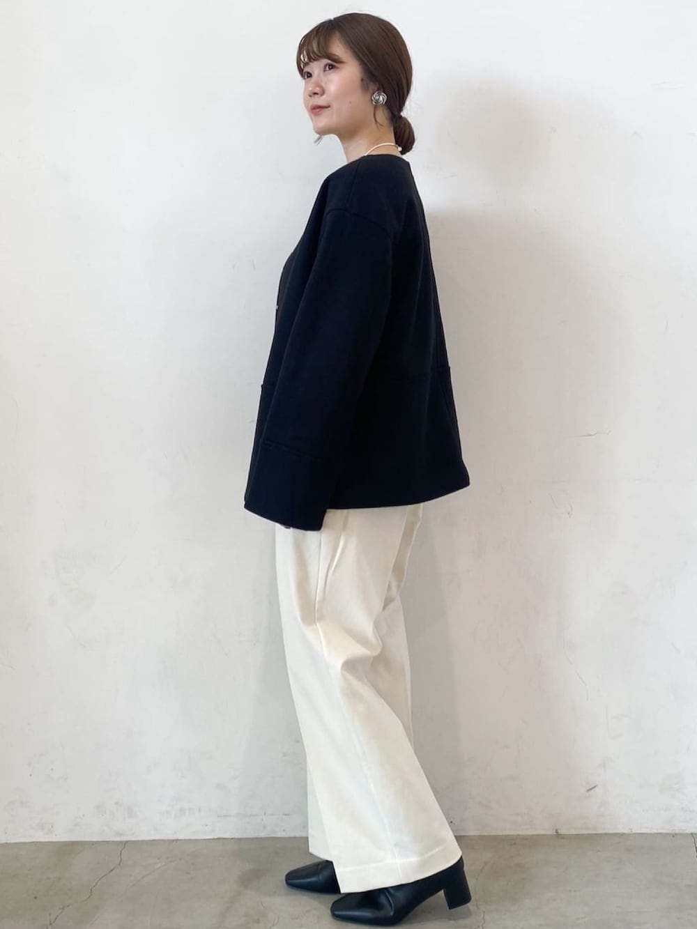 ホワイト系のその他パンツ、ブラック系のブーツ、ブラック系のノーカラーコートを着用したレディースの秋コーディネートの2枚目の写真