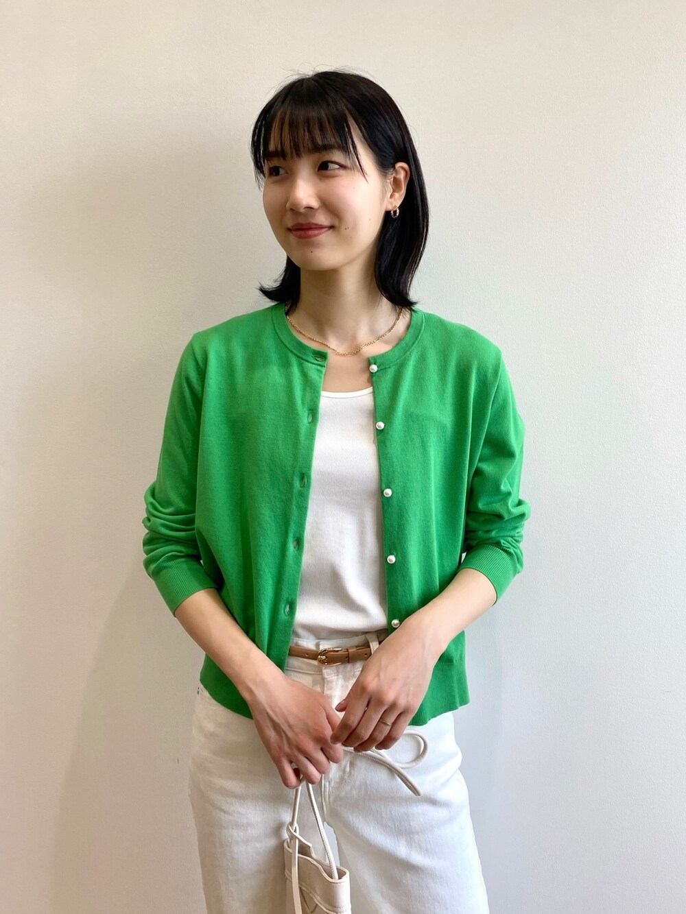 ブラウン系のサンダル、ホワイト系のショルダーバッグ、ホワイト系のデニムパンツを着用したレディースの春コーディネートの4枚目の写真