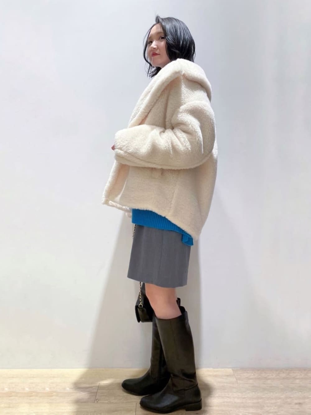 ブルー系のニット/セーター、グレー系のその他パンツ、ブラック系のブーツを着用したレディースの冬コーディネートの3枚目の写真