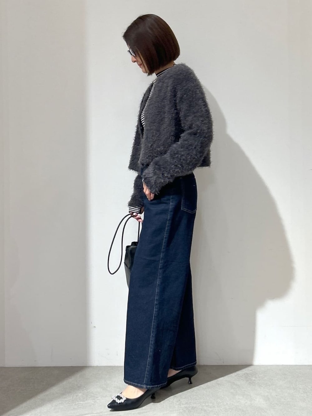 グレー系のカーディガン/ボレロ、ブルー系のその他パンツ、ブラック系のショルダーバッグを着用したレディースの冬コーディネートの3枚目の写真