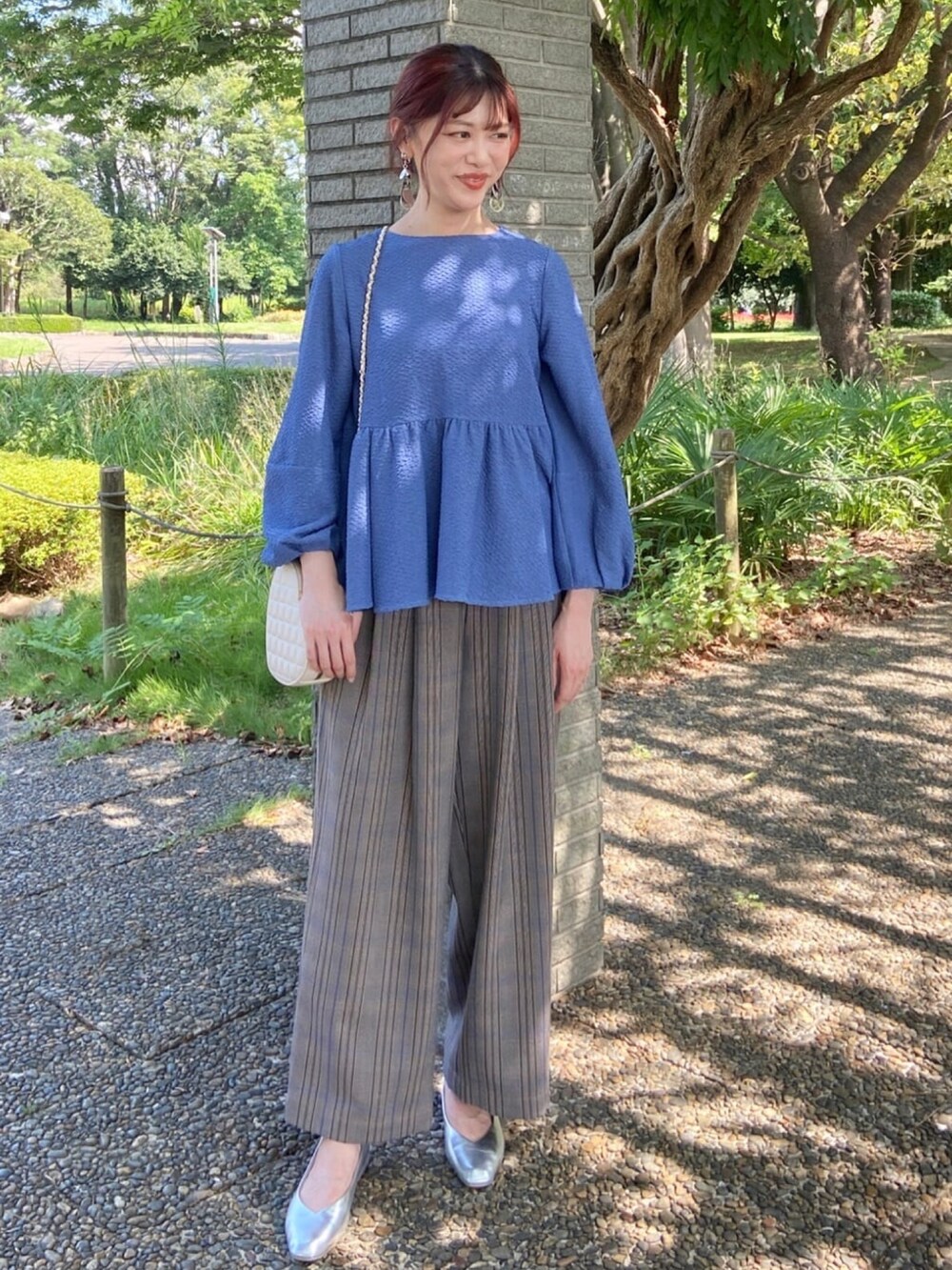 ブルー系のシャツ/ブラウス、シルバー系のパンプス、ブラウン系のその他パンツを着用したレディースの秋コーディネートの2枚目の写真