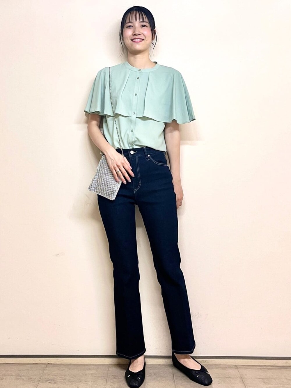 グリーン系のシャツ/ブラウス、ブラック系のパンプス、ブルー系のデニムパンツを着用したレディースの夏コーディネートの2枚目の写真