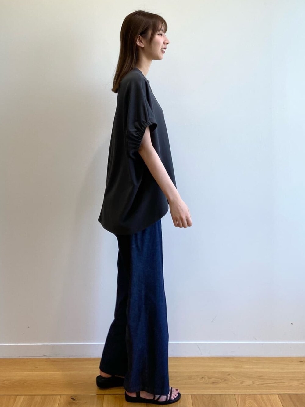グレー系のTシャツ/カットソー、ブルー系のデニムパンツ、ブラック系のサンダルを着用したレディースの春コーディネートの4枚目の写真