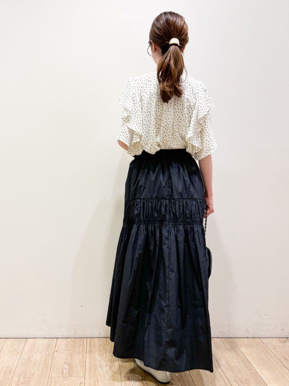 ホワイト系のシャツ/ブラウス、ブラック系のスカート、ブラック系のショルダーバッグを着用したレディースの夏コーディネートの3枚目の写真