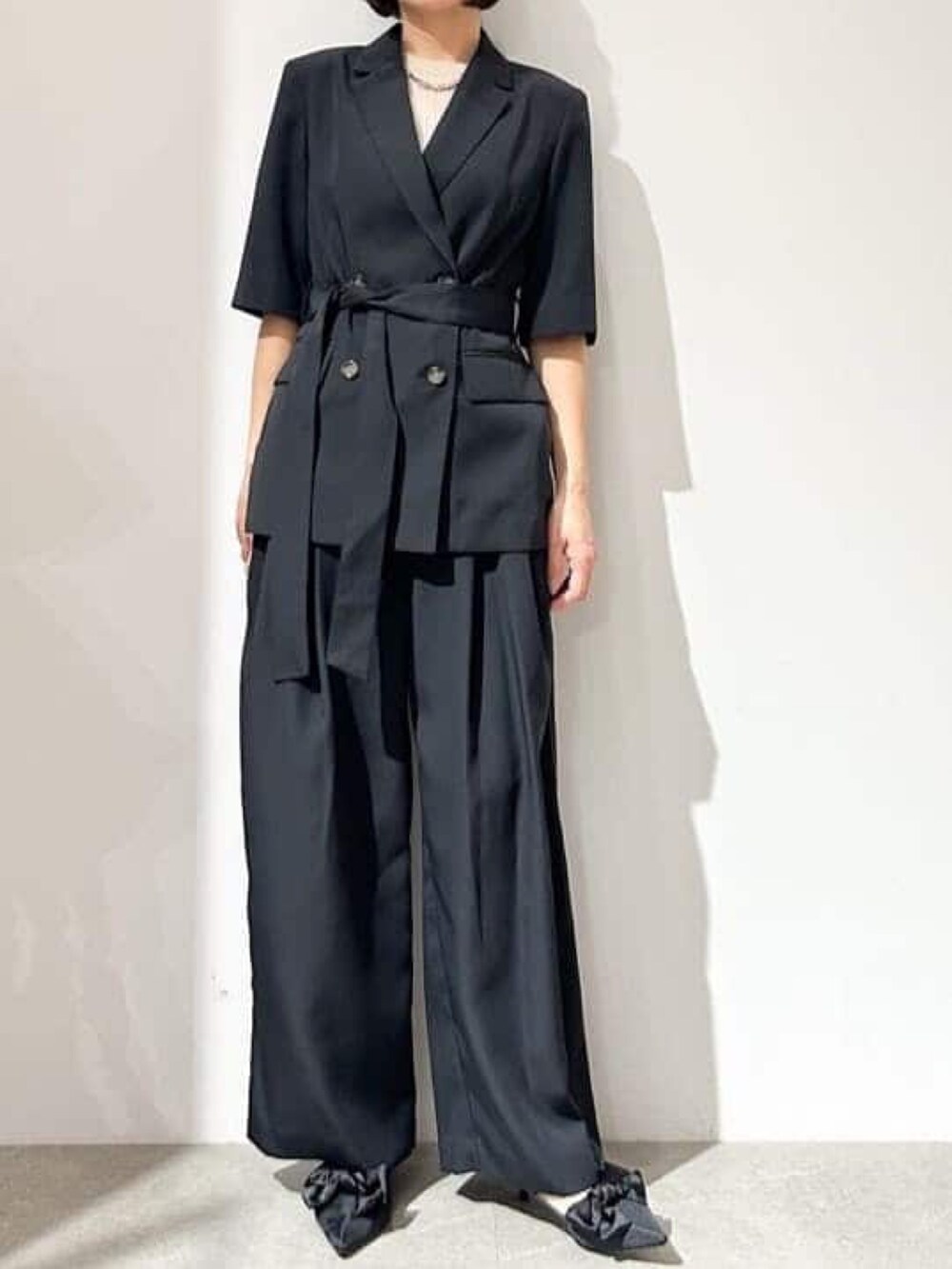 ブラック系のその他パンツ、ブラック系のパンプス、ブラック系のテーラードジャケットを着用したレディースの春コーディネートの3枚目の写真