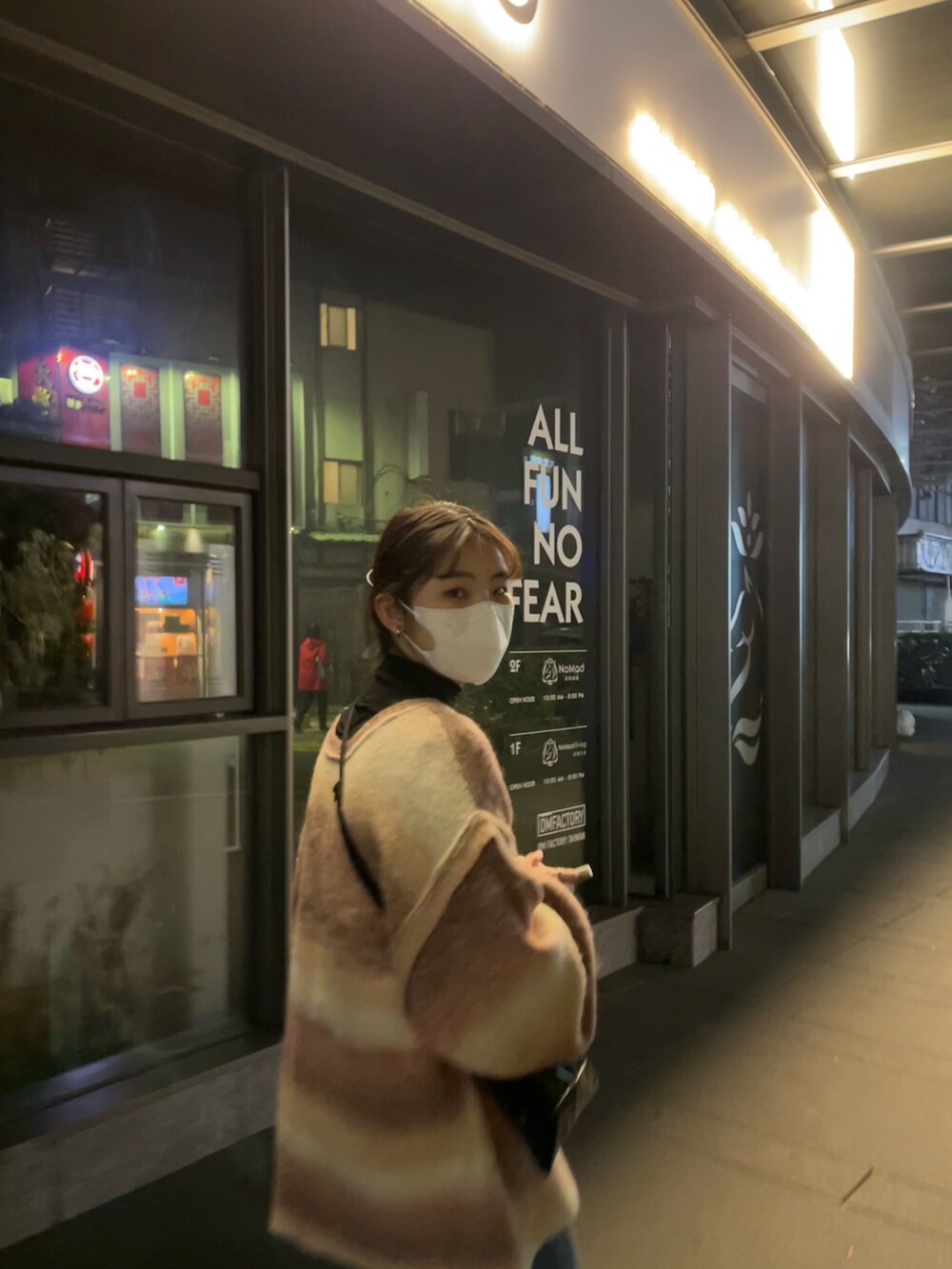 ピンク系のカーディガン/ボレロ、ブルー系のデニムパンツ、オレンジ系のスニーカーを着用したレディースの冬コーディネートの2枚目の写真