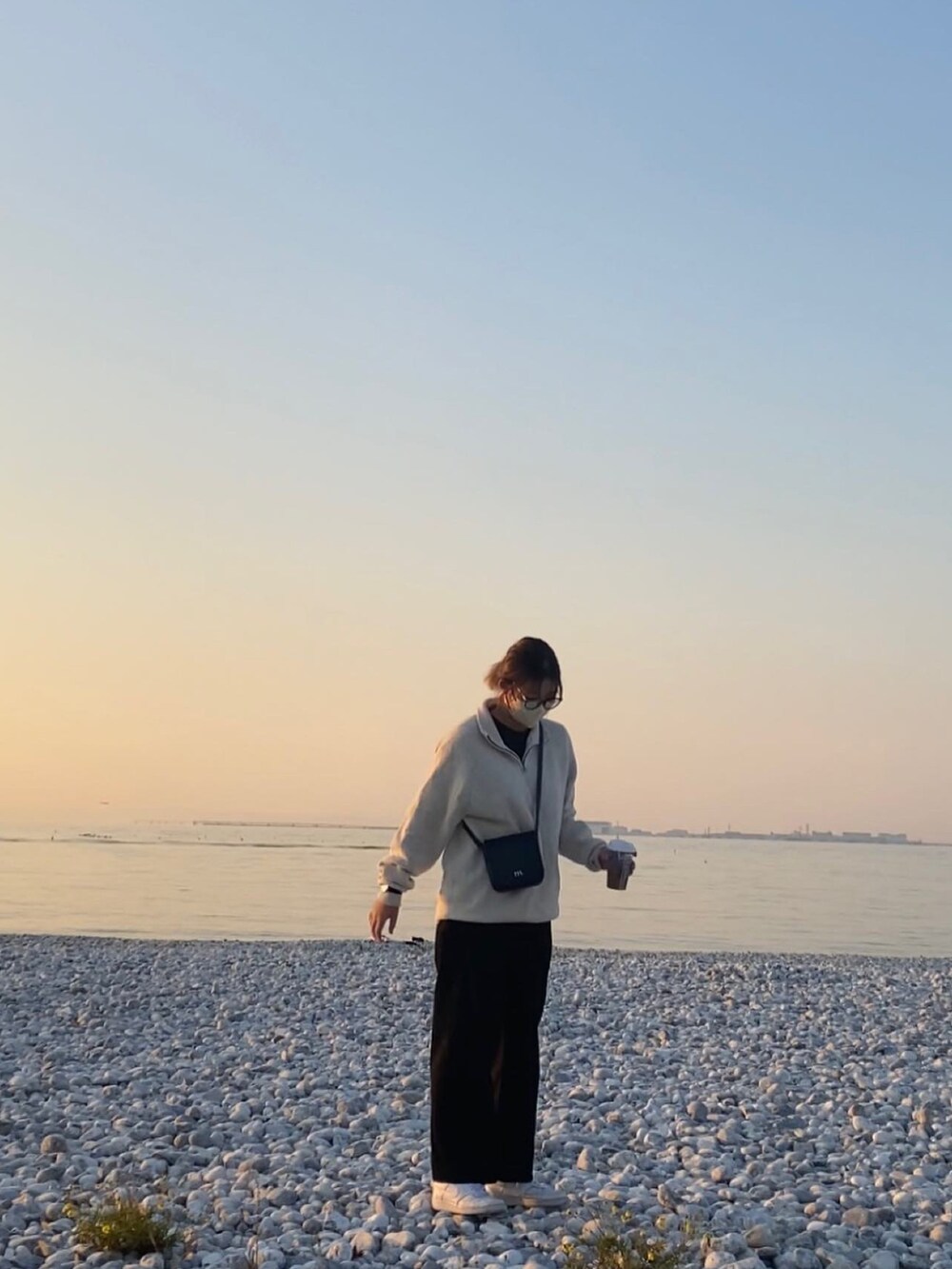 ベージュ系のニット/セーター、ブラック系のスラックスを着用したレディースの秋コーディネートの2枚目の写真