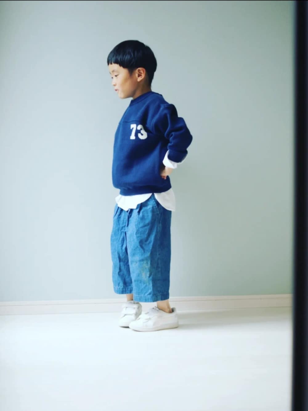 ブルー系のニット/セーター、ホワイト系のシャツ/ブラウス、ホワイト系のスニーカーを着用したキッズの春コーディネートの2枚目の写真