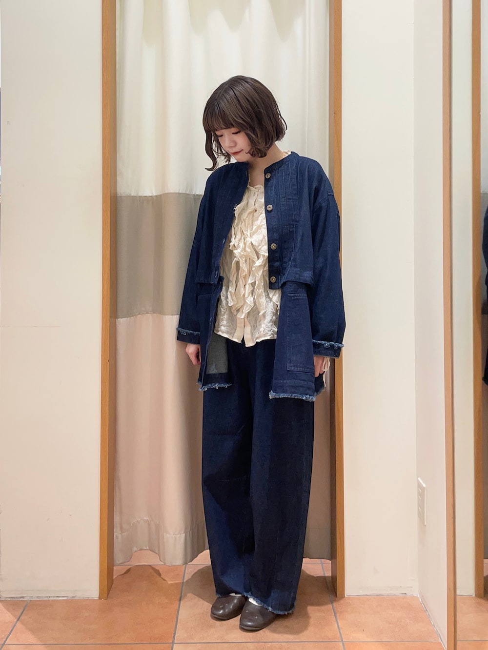 ブルー系のブルゾン、ブルー系のデニムパンツ、ホワイト系のシャツ/ブラウスを着用したレディースの秋コーディネートの2枚目の写真