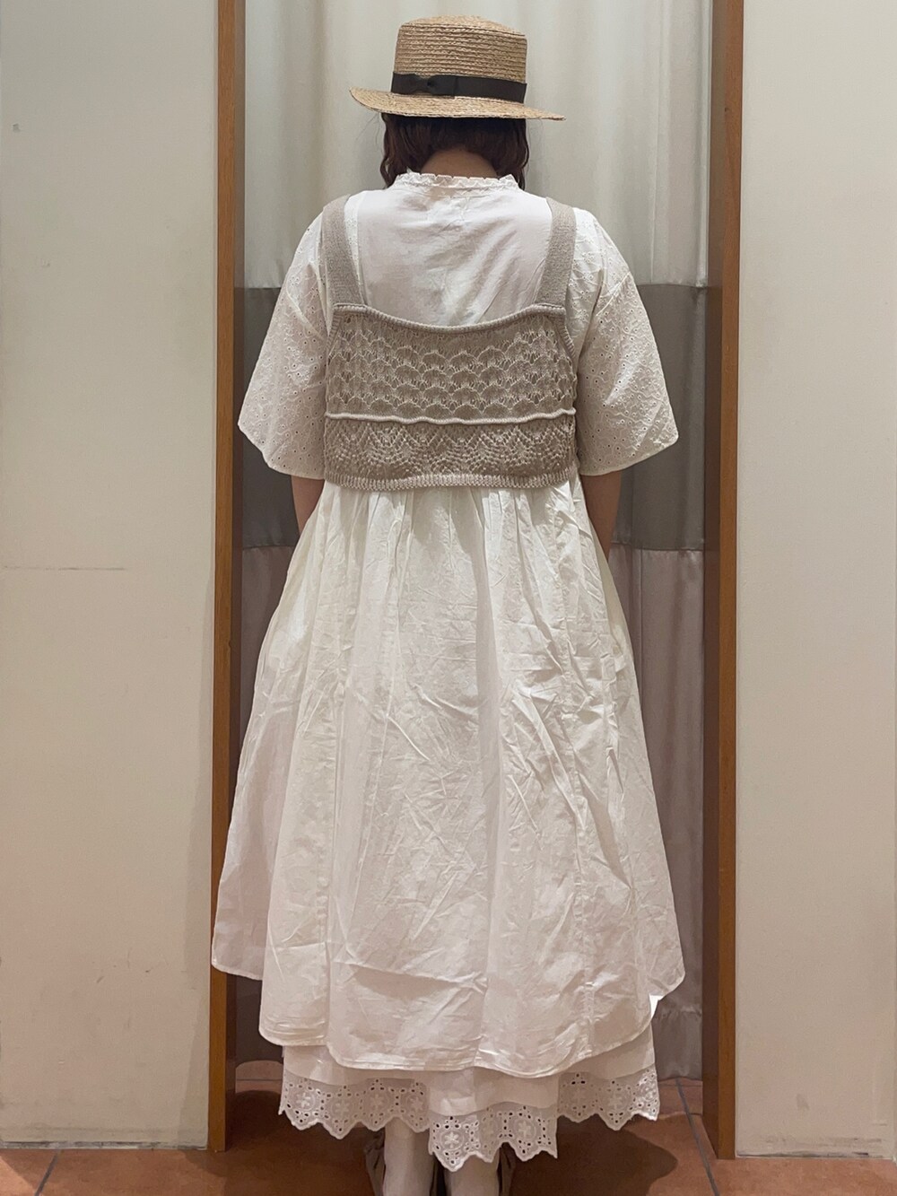 ホワイト系のワンピース、ホワイト系のスカート、ベージュ系のベストを着用したレディースの春コーディネートの4枚目の写真