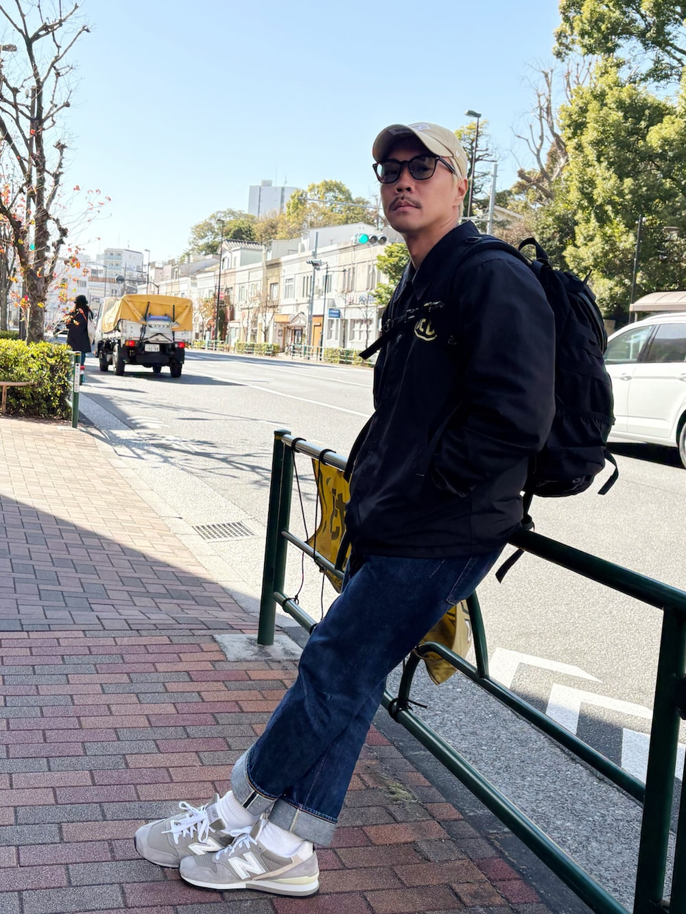 ブラック系のナイロンジャケット、グリーン系のスウェット、ブルー系のデニムパンツを着用したメンズの冬コーディネートの2枚目の写真