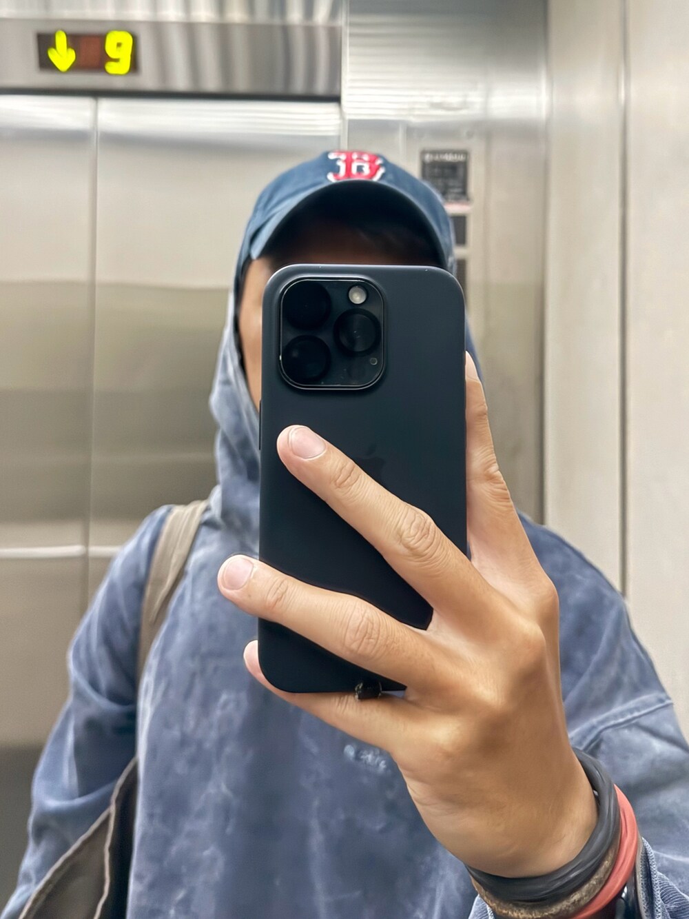 ブルー系のジャージ、ブラック系のチノパンツ、ブラウン系のトートバッグを着用したメンズの春コーディネートの3枚目の写真