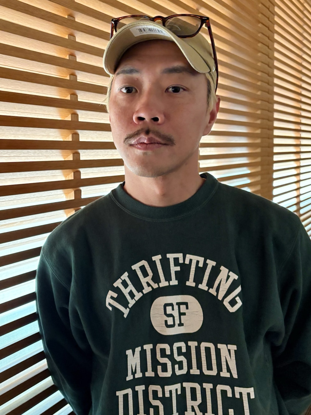 ブラック系のナイロンジャケット、グリーン系のスウェット、ブルー系のデニムパンツを着用したメンズの冬コーディネートの4枚目の写真