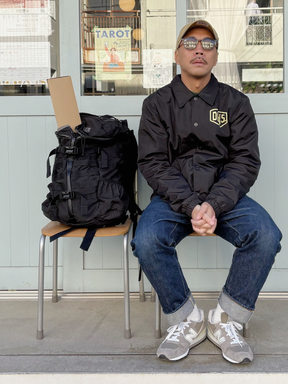 ブラック系のナイロンジャケット、グリーン系のスウェット、ブルー系のデニムパンツを着用したメンズの冬コーディネートの3枚目の写真