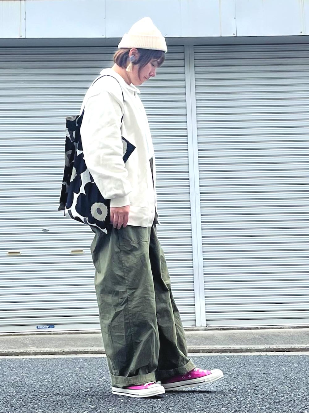 ホワイト系のカーディガン/ボレロ、グリーン系のカーゴパンツ、ブラック系のトートバッグを着用したレディースの春コーディネートの2枚目の写真