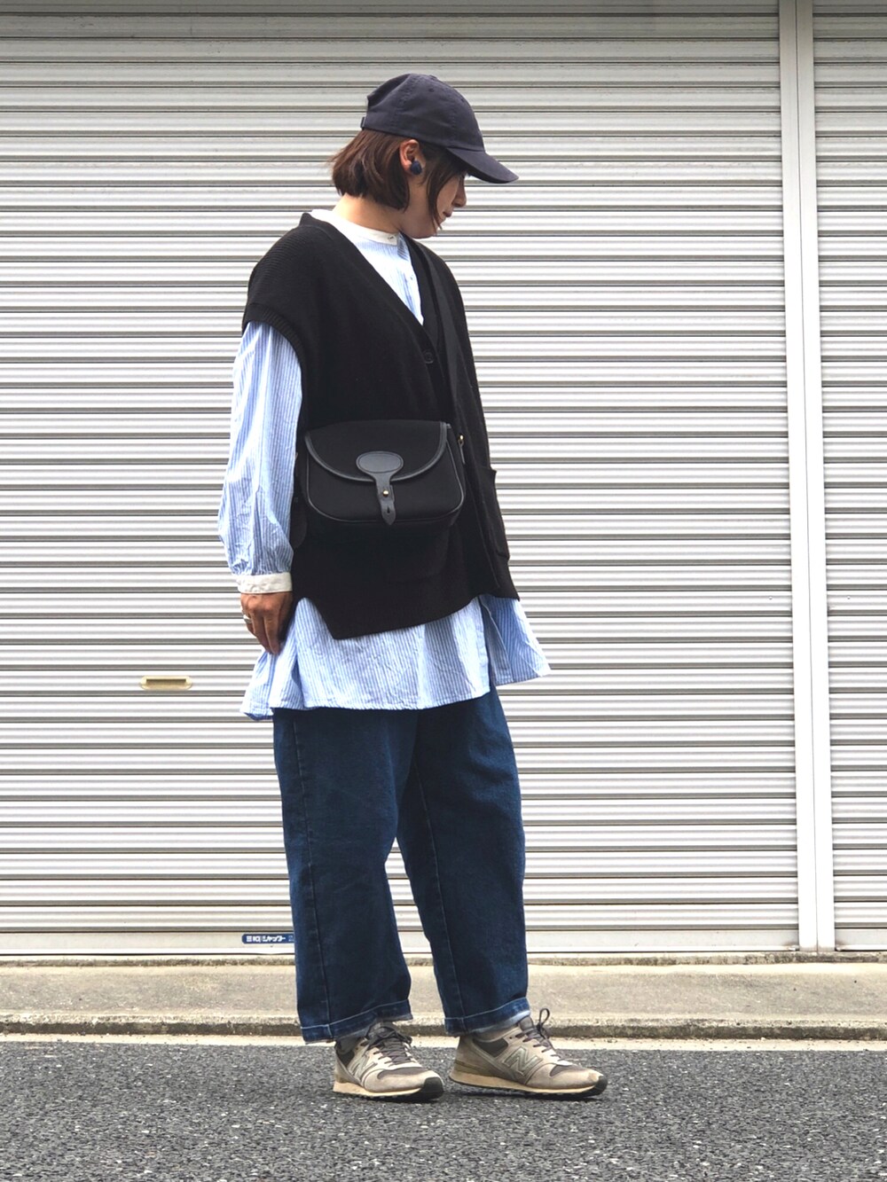 ブルー系のシャツ/ブラウス、ブラック系のベスト、ブラック系のショルダーバッグを着用したレディースの春コーディネートの2枚目の写真