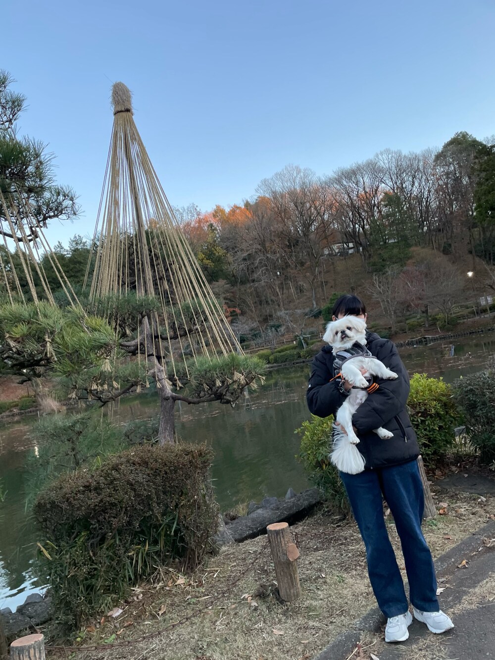 ブルー系のデニムパンツ、グレー系のスニーカー、ブラック系のダウンジャケット/コートを着用したレディースの冬コーディネートの2枚目の写真