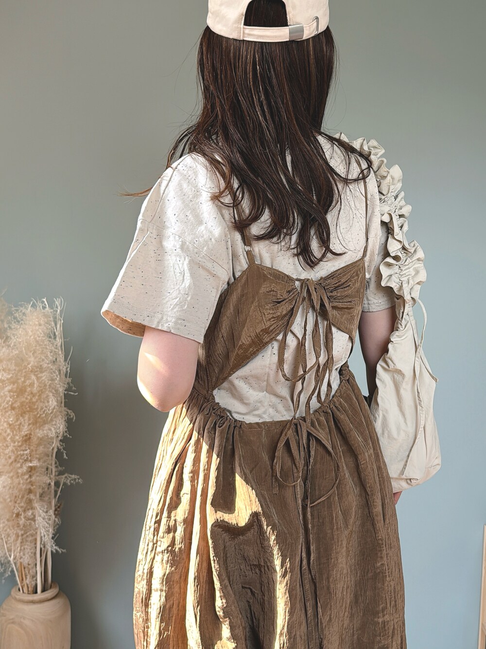 ブラウン系のワンピース、ホワイト系のショルダーバッグ、ベージュ系のTシャツ/カットソーを着用したレディースの春コーディネートの3枚目の写真