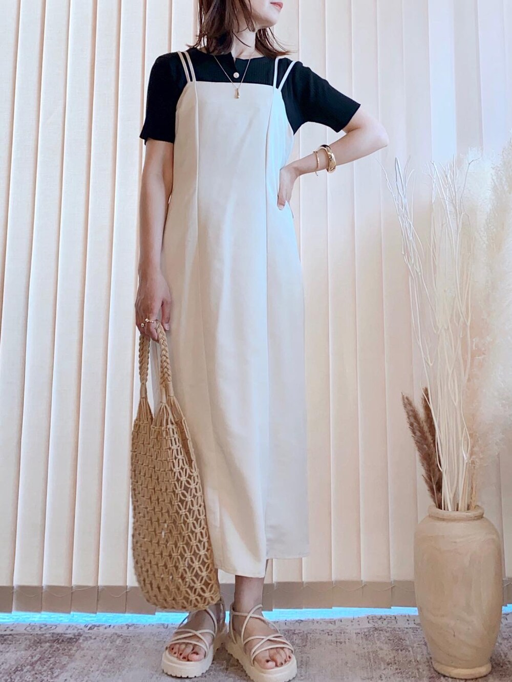 ホワイト系のワンピース、ブラック系のカーディガン/ボレロ、イエロー系のタンクトップを着用したレディースの夏コーディネートの2枚目の写真