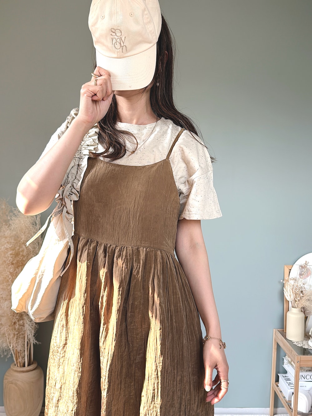 ブラウン系のワンピース、ホワイト系のショルダーバッグ、ベージュ系のTシャツ/カットソーを着用したレディースの春コーディネートの2枚目の写真