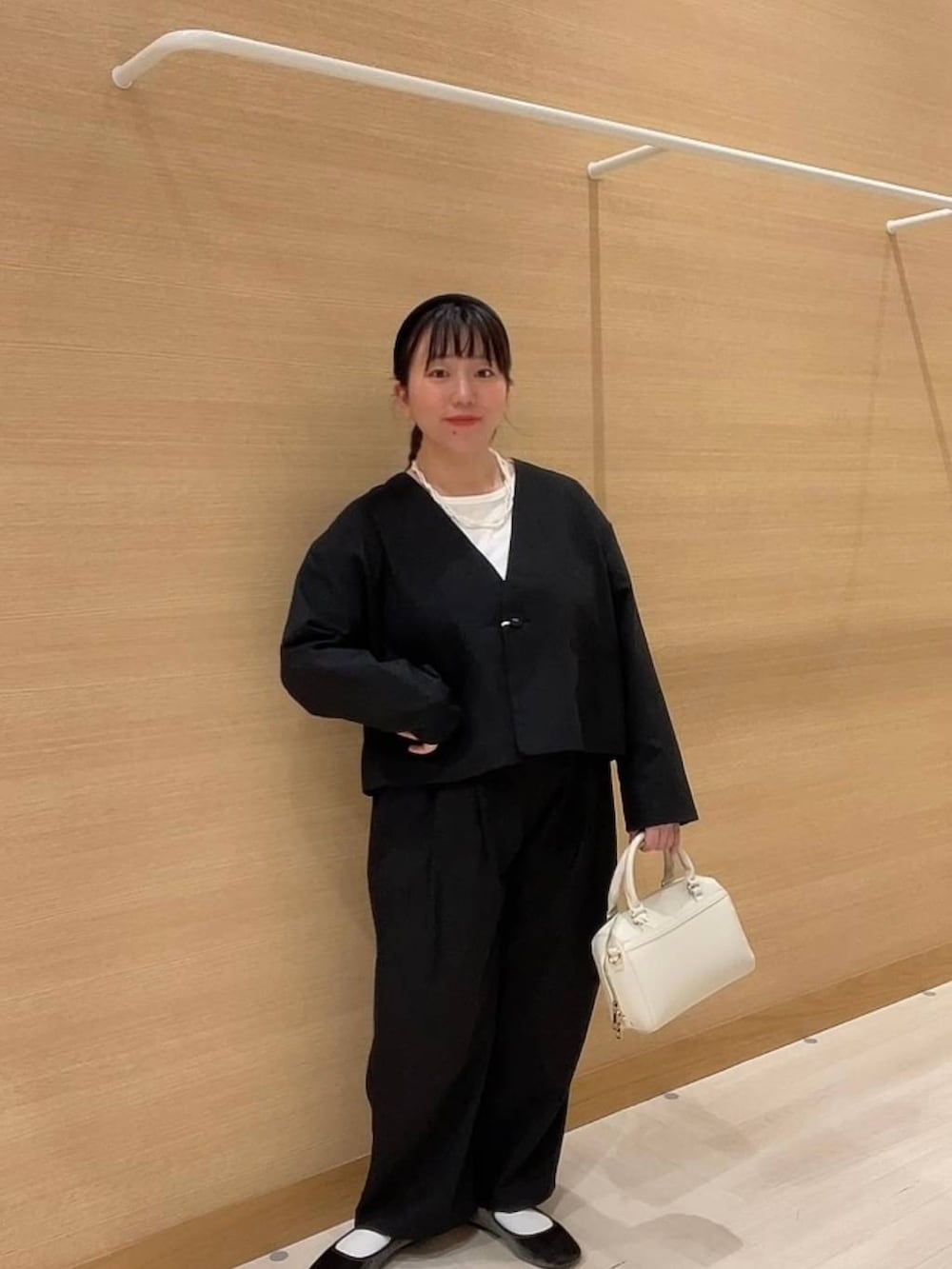 グリーン系のパンプス、ホワイト系のショルダーバッグ、ブラック系のノーカラージャケットを着用したレディースの冬コーディネートの4枚目の写真