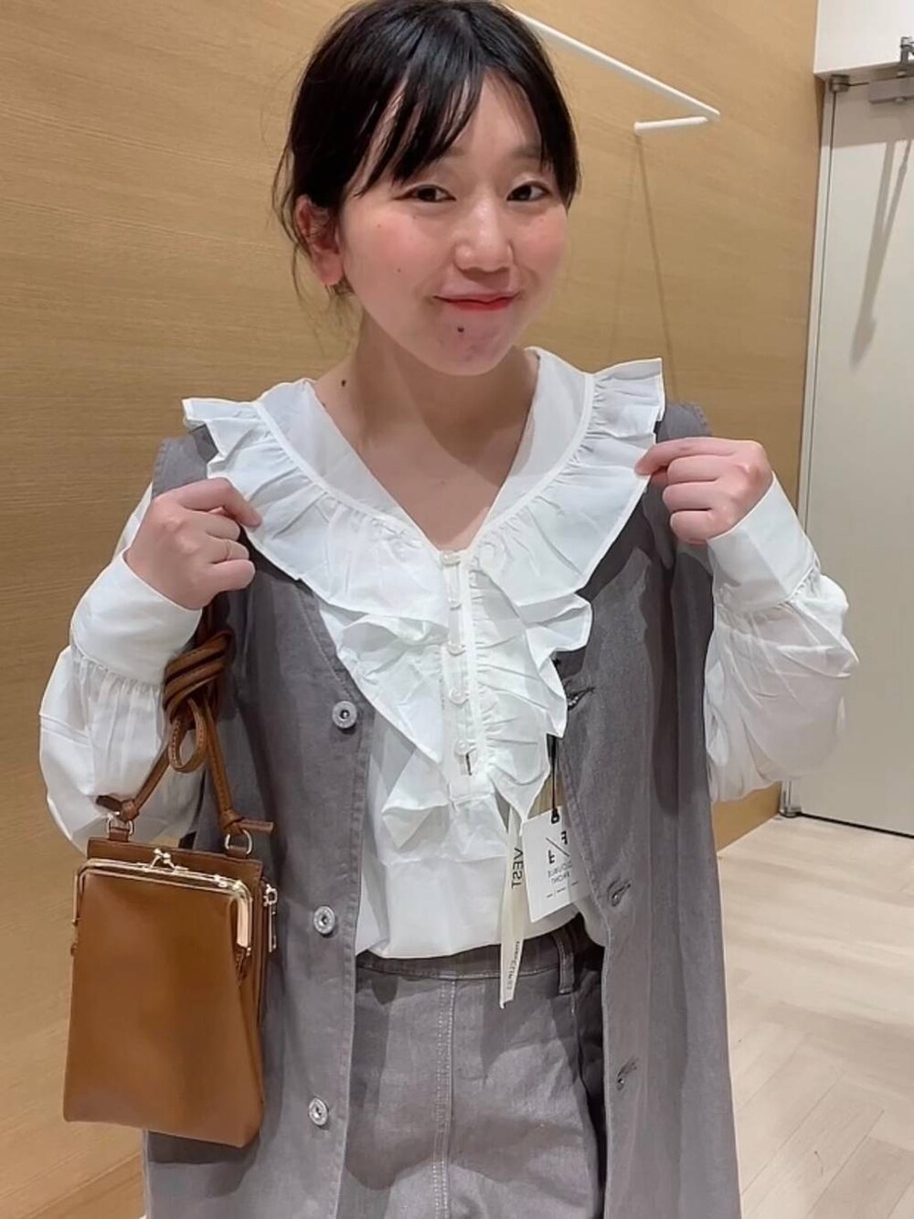 ホワイト系のシャツ/ブラウス、ブラウン系のデニムパンツ、ブラウン系のベストを着用したレディースの冬コーディネートの9枚目の写真