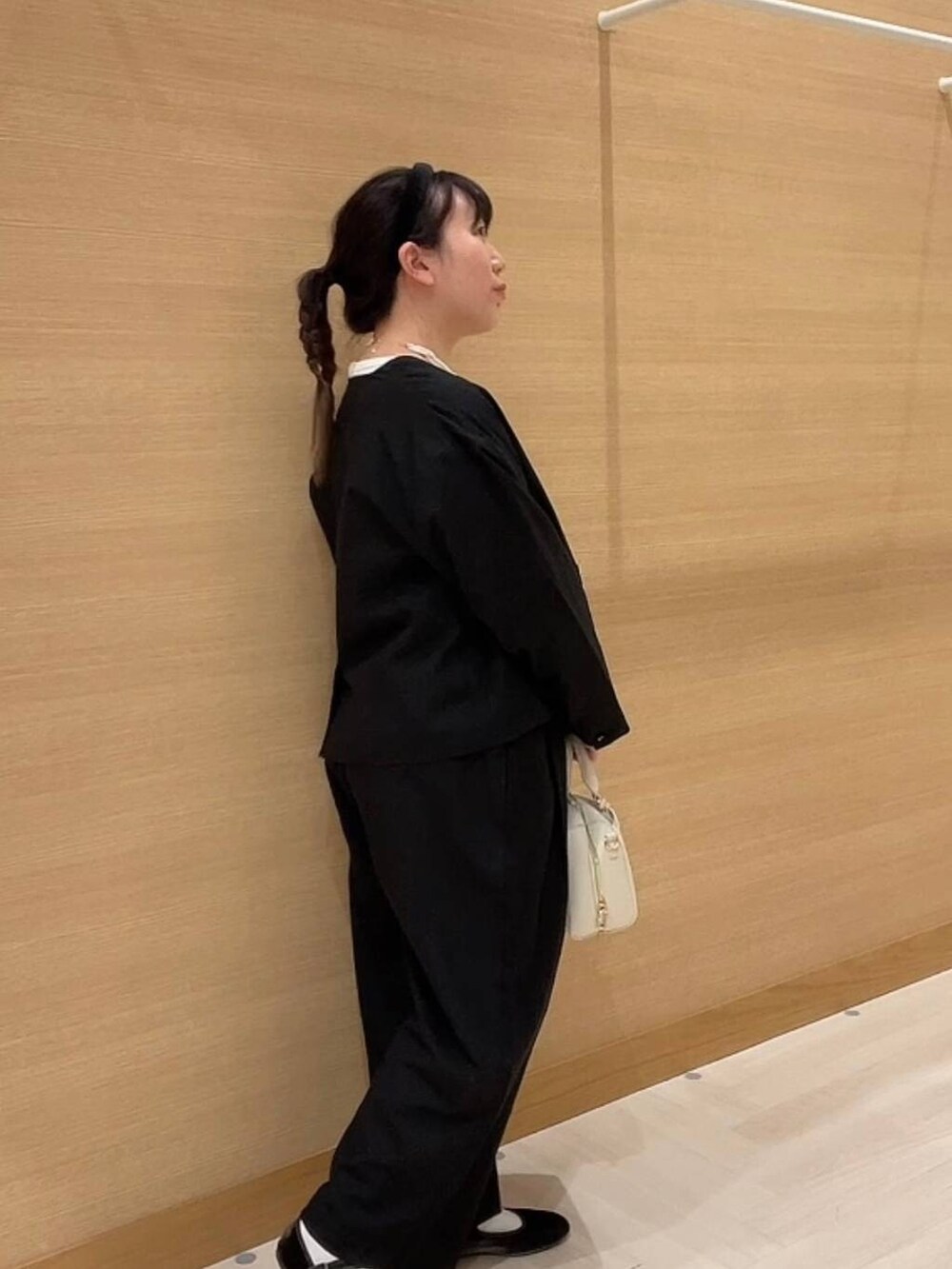 グリーン系のパンプス、ホワイト系のショルダーバッグ、ブラック系のノーカラージャケットを着用したレディースの冬コーディネートの6枚目の写真