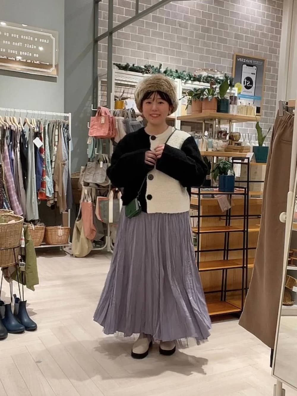 ベージュ系のブーツ、ブラック系のニット/セーター、パープル系のスカートを着用したレディースの冬コーディネートの5枚目の写真