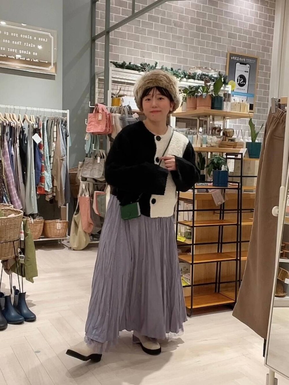 ベージュ系のブーツ、ブラック系のニット/セーター、パープル系のスカートを着用したレディースの冬コーディネートの10枚目の写真