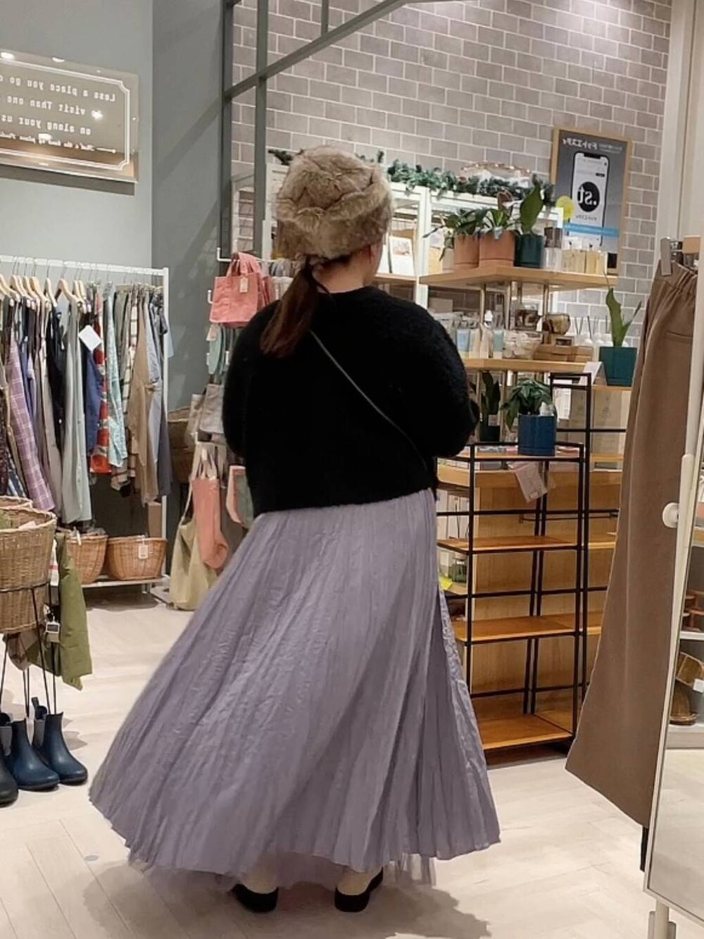 ベージュ系のブーツ、ブラック系のニット/セーター、パープル系のスカートを着用したレディースの冬コーディネートの3枚目の写真