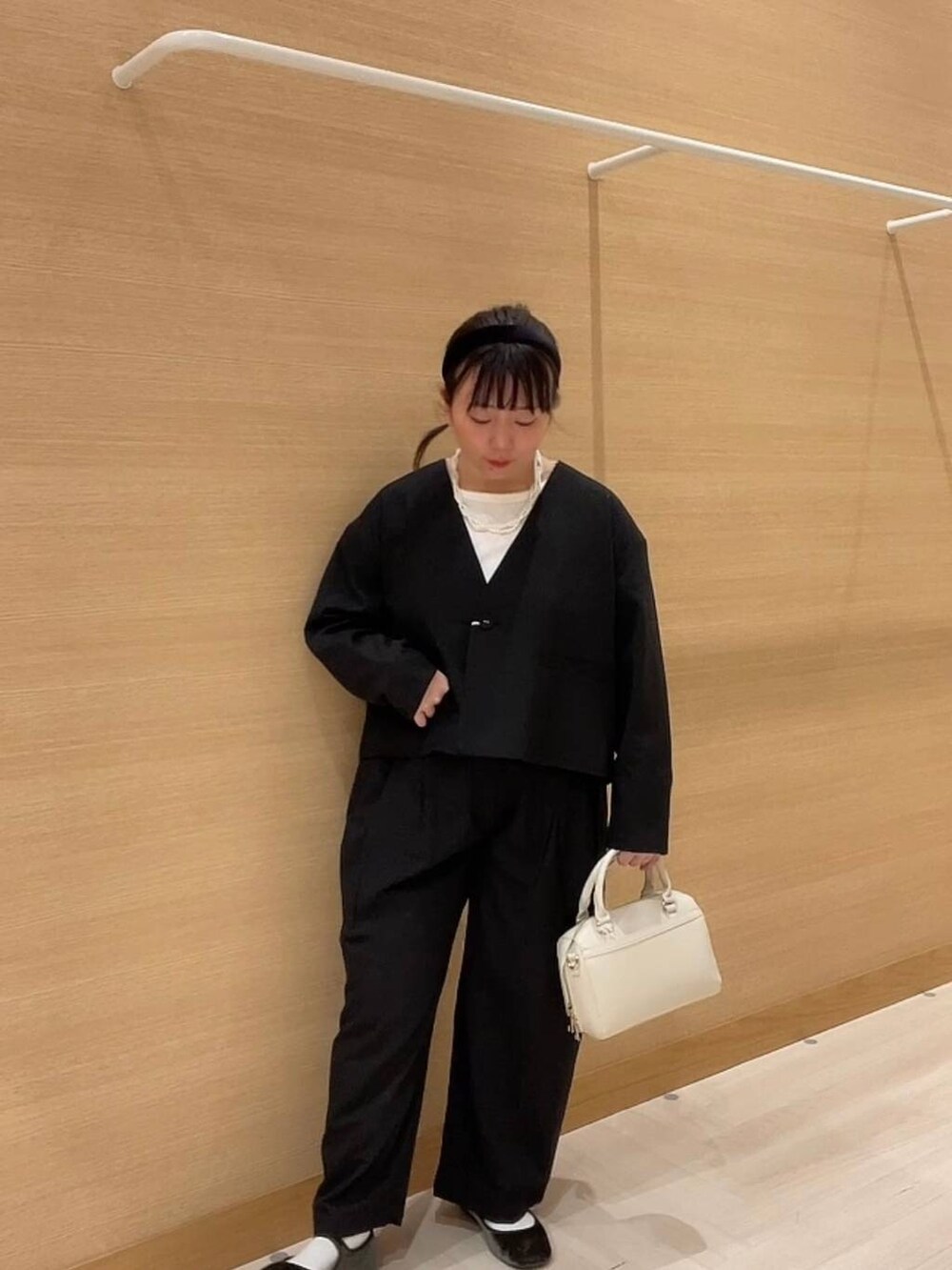 グリーン系のパンプス、ホワイト系のショルダーバッグ、ブラック系のノーカラージャケットを着用したレディースの冬コーディネートの8枚目の写真