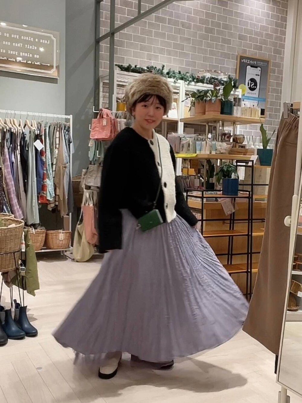 ベージュ系のブーツ、ブラック系のニット/セーター、パープル系のスカートを着用したレディースの冬コーディネートの9枚目の写真