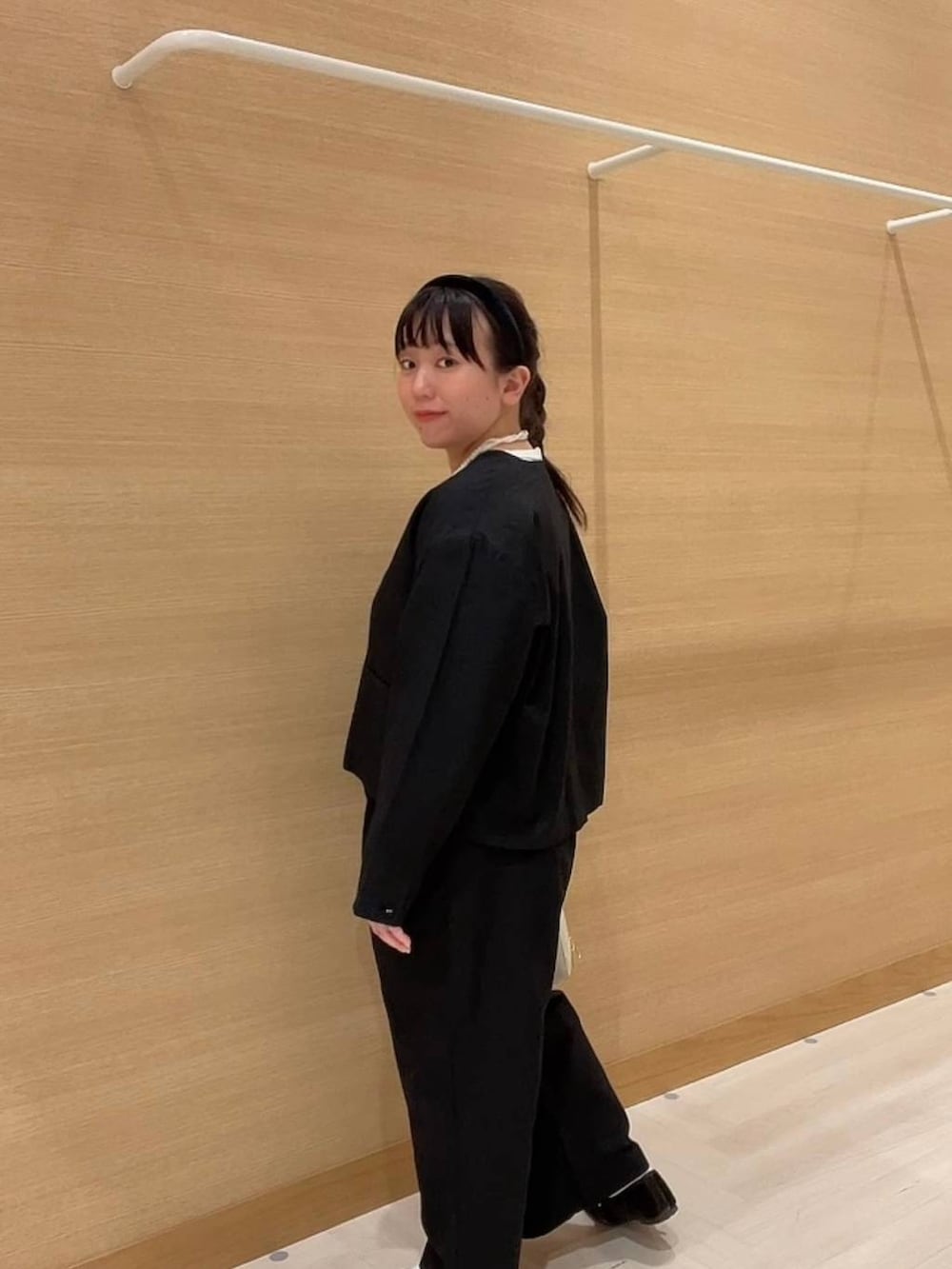 グリーン系のパンプス、ホワイト系のショルダーバッグ、ブラック系のノーカラージャケットを着用したレディースの冬コーディネートの5枚目の写真