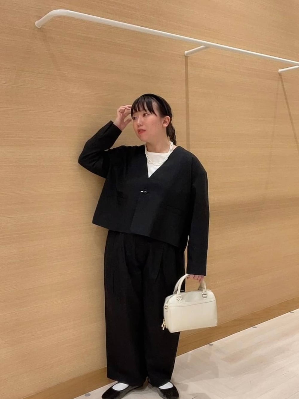 グリーン系のパンプス、ホワイト系のショルダーバッグ、ブラック系のノーカラージャケットを着用したレディースの冬コーディネートの7枚目の写真