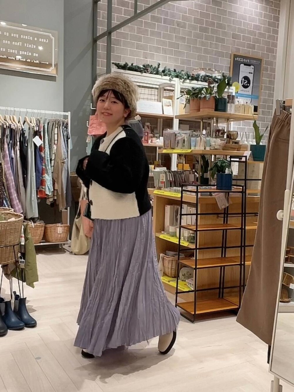 ベージュ系のブーツ、ブラック系のニット/セーター、パープル系のスカートを着用したレディースの冬コーディネートの6枚目の写真