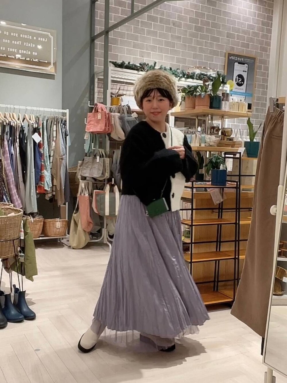 ベージュ系のブーツ、ブラック系のニット/セーター、パープル系のスカートを着用したレディースの冬コーディネートの8枚目の写真