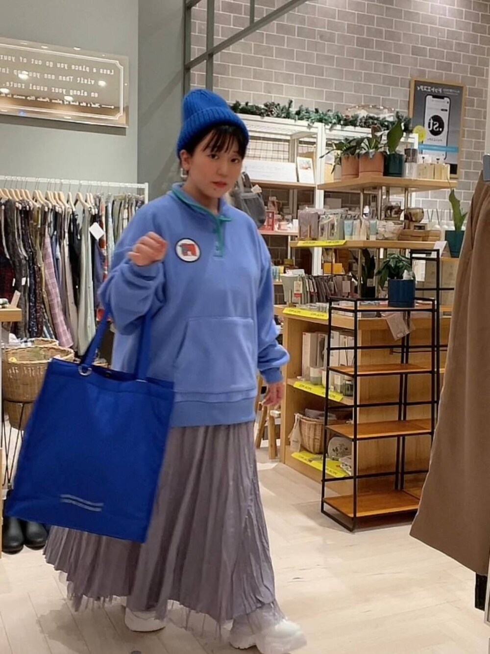 ブルー系のショルダーバッグ、パープル系のスカート、ホワイト系のスニーカーを着用したレディースの冬コーディネートの10枚目の写真