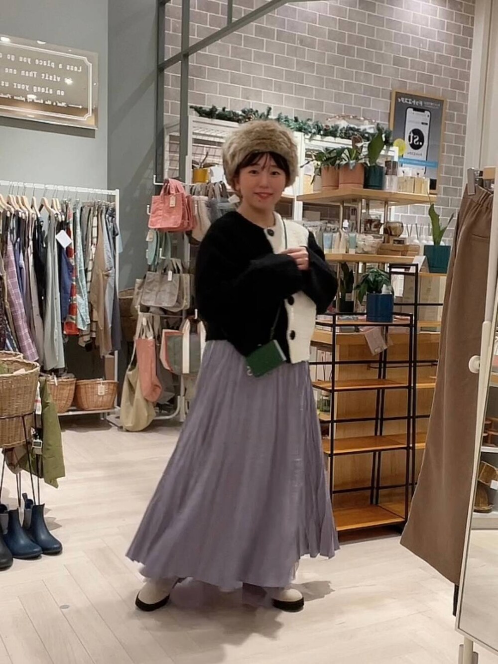 ベージュ系のブーツ、ブラック系のニット/セーター、パープル系のスカートを着用したレディースの冬コーディネートの7枚目の写真