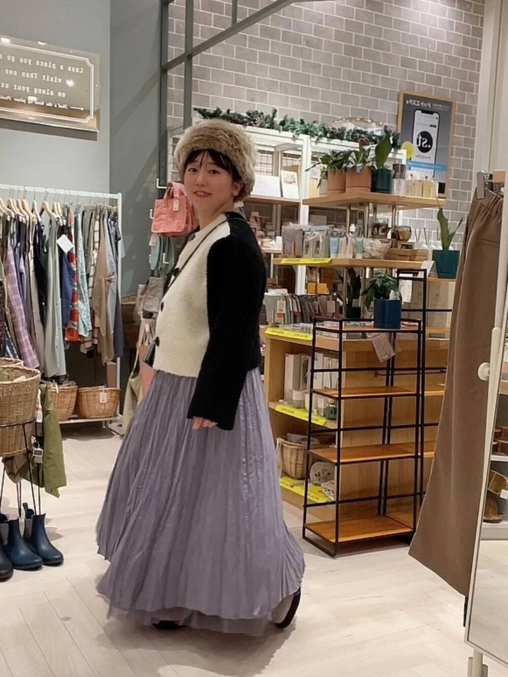 ベージュ系のブーツ、ブラック系のニット/セーター、パープル系のスカートを着用したレディースの冬コーディネートの2枚目の写真