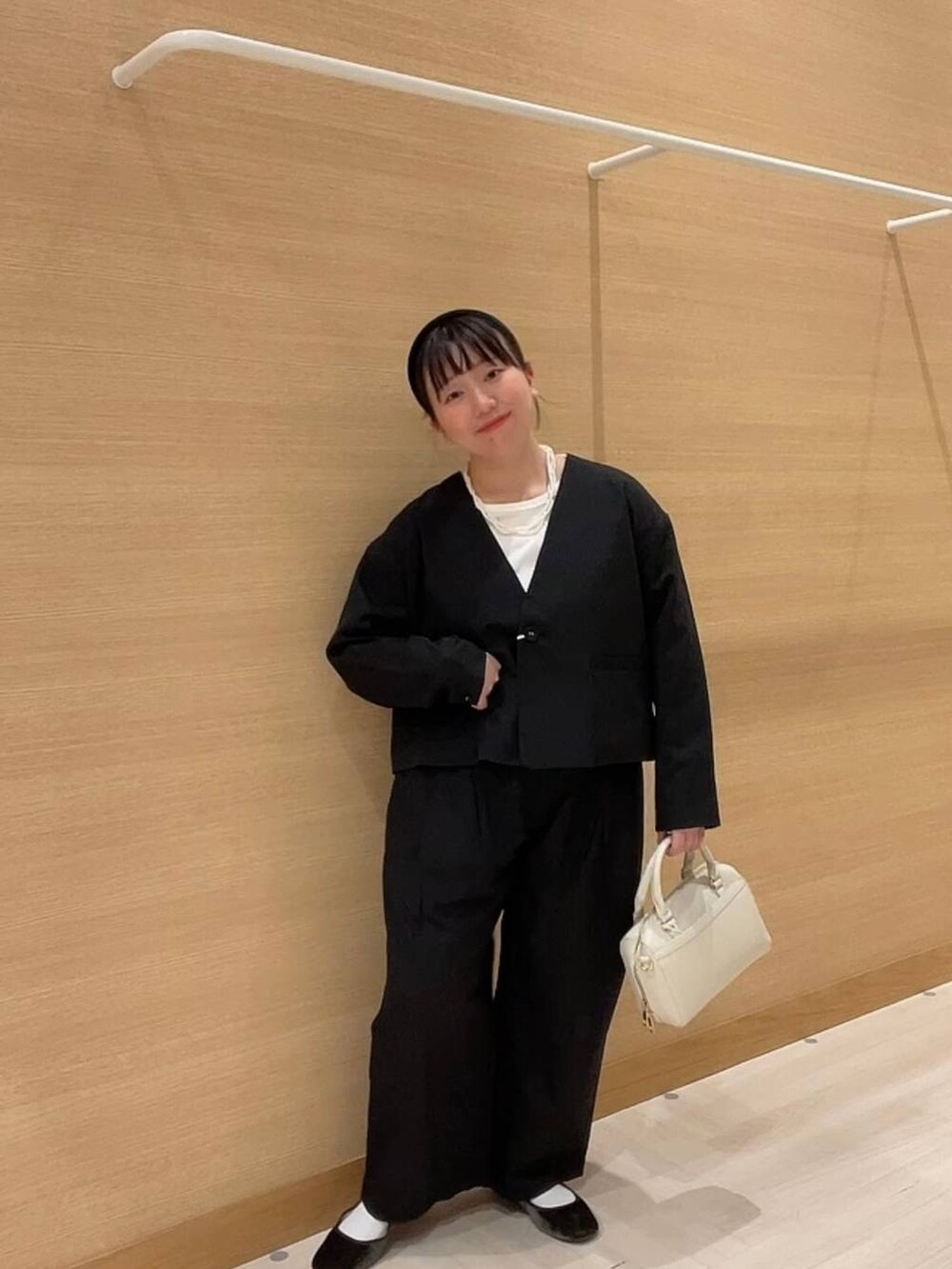 グリーン系のパンプス、ホワイト系のショルダーバッグ、ブラック系のノーカラージャケットを着用したレディースの冬コーディネートの10枚目の写真