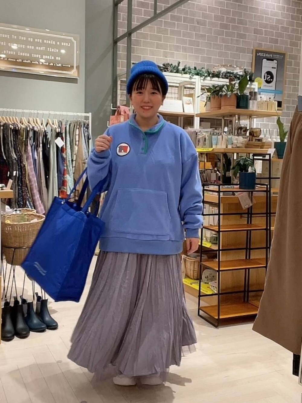 ブルー系のショルダーバッグ、パープル系のスカート、ホワイト系のスニーカーを着用したレディースの冬コーディネートの4枚目の写真